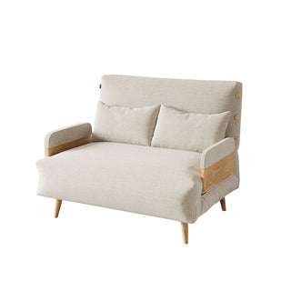 A beige linen convertible loveseat features wooden armrests, tapered legs, and button-tufted side details against a clean white background. Two matching rectangular lumbar pillows rest neatly against its supportive backrest. This versatile piece combines a cozy modern aesthetic with functional design.