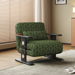 A modern green textured armchair sits centered in a bright room with a large window covered by horizontal blinds. The chair features distinct dark wooden legs and flat armrests with decorative diamond inlay accents on the side supports. A matching elongated lumbar pillow rests against its cushioned backrest. A textured area rug and a corner cabinet complete the cozy interior setup.