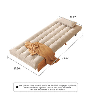 A product dimension diagram illustrates a fully flattened beige linen tufted convertible armchair on a white background. A single rectangular pillow is placed neatly at the head of the bed, and a warm yellow throw blanket drapes across the side. Dimension lines indicate a length of 76.57 inches, a width of 27.56 inches, and a top width of 26.77 inches.