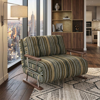 A modern armchair upholstered in dark striped fabric with green, black, and beige tones sits on a patterned neutral area rug over a wooden floor. The chair features button-tufted back cushions, wooden armrests, and a sleek sled base. In the background, a luxury high-rise apartment with a sweeping city skyline view through floor-to-ceiling windows, an elegant wall-mounted lamp, and a built-in wooden cabinet completes the sophisticated urban setting.
