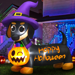Giant Halloween inflatable dachshund dog yard decoration wearing a purple witch hat and holding a glowing jack-o-lantern pumpkin candy bucket, featuring "Happy Halloween" lettering on the body for outdoor holiday lawn displays.