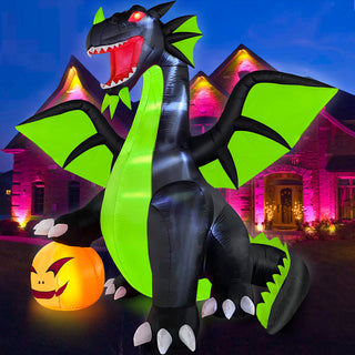 Illuminated nighttime outdoor display of a large Halloween inflatable black and neon green dragon featuring glowing red eyes and a bright pumpkin in front of a house.