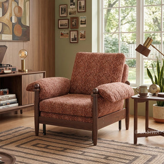 Lifestyle staging shot of a brown textured accent armchair featuring dark wood framing and plush cushions in a cozy, art-filled living room.