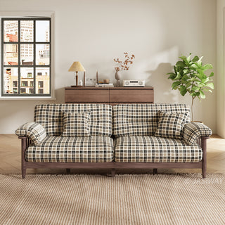Front view of a plaid fabric sofa with dark wooden frame styled in a bright modern living room