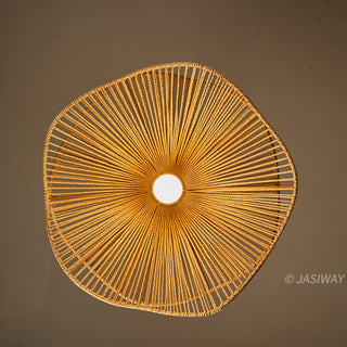 A top-down view of the intricate hand-woven rope pendant light, featuring a symmetrical, radiant starburst pattern formed by the tightly strung natural fibers emanating from a central glowing bulb. The warm, organic texture of the rope defines the sophisticated geometric form, creating an earthy yet refined statement piece. This light fixture, with its artisanal craftsmanship and captivating play of light and shadow, anchors the space in a curated, globally-inspired modern aesthetic.
