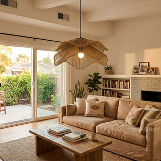 This inviting living room features a plush, neutral-toned sofa paired with a rustic wooden coffee table, creating a warm and grounded atmosphere. A large, hand-woven rope pendant light serves as a sculptural focal point, casting soft light over the space. Through the sliding glass doors, a view of a sunlit garden connects the interior to the outdoors, completing this serene and curated home aesthetic.