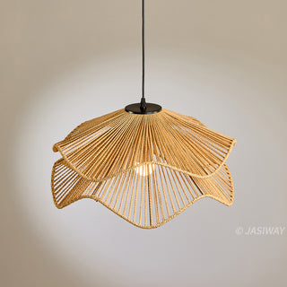A pendant light fixture made of tightly woven, natural light-brown fibers hangs against a soft, light-grey background. Its unique, two-tiered lampshade features an undulating design that resembles the delicate, overlapping petals of a flower. Suspended by a sleek black cord, the fixture reveals a single glowing bulb shining from within. 