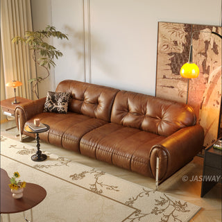 JASIWAY mid-century modern 3-seater sofa in rich vintage brown leather, featuring deep-seated cushions with classic tufted backrest detailing, thick rolled arms accented by sleek vertical metal legs, and an elegant low-profile silhouette designed for high-end residential interiors.-High-angle view
