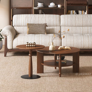 JASIWAY mid-century modern round coffee table set crafted from rich walnut-finished solid wood, a lower open storage shelf holding books, and an architectural leg design with elegant turned wood detailing. The tall, slim accent end table showcases a matching round wooden top supported by a sculptural pedestal base with a dark metal floor plate, styled alongside a warm contemporary living room sofa.-Front view