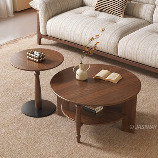 JASIWAY mid-century modern round coffee table set crafted from rich walnut-finished solid wood, a lower open storage shelf holding books, and an architectural leg design with elegant turned wood detailing. The tall, slim accent end table showcases a matching round wooden top supported by a sculptural pedestal base with a dark metal floor plate, styled alongside a warm contemporary living room sofa.-High-angle view
