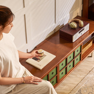 JASIWAY mid-century modern TV stand featuring a rich walnut and boxwood finish, sliding cabinet doors with olive green grid accents, and open tempered glass shelving, blending organic retro aesthetics with functional storage for upscale living room entertainment centers.-High-angle medium shot