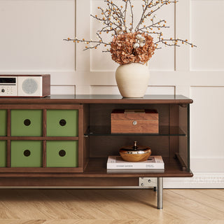 JASIWAY mid-century modern TV stand featuring a rich walnut and boxwood finish, sliding cabinet doors with olive green grid accents, and open tempered glass shelving, blending organic retro aesthetics with functional storage for upscale living room entertainment centers.-Medium shot of open storage