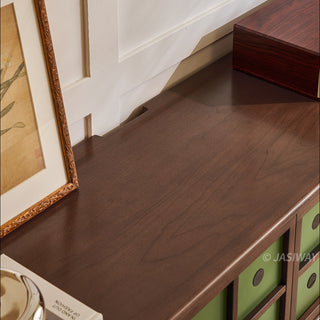 JASIWAY mid-century modern TV stand featuring a rich walnut and boxwood finish, sliding cabinet doors with olive green grid accents, and open tempered glass shelving, blending organic retro aesthetics with functional storage for upscale living room entertainment centers.-Close-up of surface