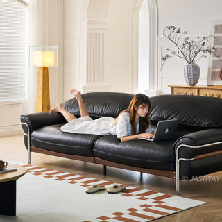 JASIWAY modern black top-grain leather sofa with adjustable headrests, luxury 3-seater couch featuring premium genuine leather upholstery, ergonomic cushioning, and sturdy wooden frame for a high-end living room aesthetic.-Three-quarter view with model lying on the sofa