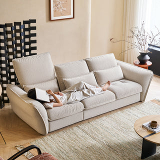 JASIWAY modern 3-seater fabric sofa with adjustable high-back headrests and deep-seated cloud cushions, featuring a low-profile minimalist design and ergonomic neck support with a high-end, contemporary aesthetic for luxury living rooms. -High-angle view with model lying down