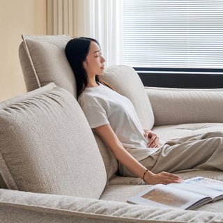 JASIWAY modern 3-seater fabric sofa with adjustable high-back headrests and deep-seated cloud cushions, featuring a low-profile minimalist design and ergonomic neck support with a high-end, contemporary aesthetic for luxury living rooms. -Side view with model leaning against the headrest