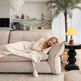 JASIWAY 3-seater fabric sofa featuring a low-profile Japandi silhouette with tufted back cushions and deep-seated upholstery, finished in a textured beige-toned linen-look bouclé fabric that emphasizes a minimalist yet sophisticated living room aesthetic.-Front medium shot with model sleeping