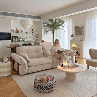 JASIWAY 3-seater fabric sofa featuring a low-profile Japandi silhouette with tufted back cushions and deep-seated upholstery, finished in a textured beige-toned linen-look bouclé fabric that emphasizes a minimalist yet sophisticated living room aesthetic.-Three-quarter view with model sitting