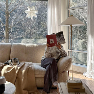 JASIWAY 3-seater fabric sofa featuring a low-profile Japandi silhouette with tufted back cushions and deep-seated upholstery, finished in a textured beige-toned linen-look bouclé fabric that emphasizes a minimalist yet sophisticated living room aesthetic.-Medium shot with model sitting