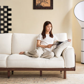 JASIWAY modern 3-seater sofa featuring a low-profile silhouette and a solid walnut-finished wood frame, upholstered in premium fabric or top grain leather, ideal for curated modern living room interiors.-Front medium shot with model sitting