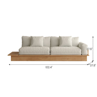 A front-facing view shows a long beige upholstered sectional sofa with a wooden base and an attached side shelf against a clean white background, complete with dimension lines and size callouts. Key measurements include an overall width of 102.4", a depth of 37.8", and a total height of 27.6". Two square accent pillows rest against the back cushions.