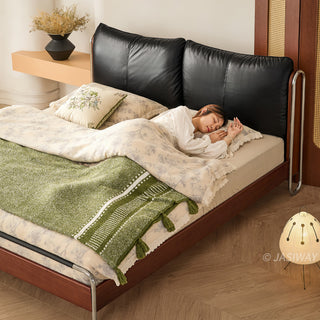 JASIWAY luxury minimalist platform bed with solid wood frame integrated with a curved chrome stainless steel tubular structure, featuring an ergonomic dual-pillow cushioned headboard upholstered in premium black leather, blending mid-century modern craftsmanship with industrial elegance, celebrated as the London Design Awards 2025 Silver Winner for master bedroom furniture design.-High- angle view with model sleeping