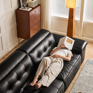 JASIWAY premium leather power reclining sleeper sofa featuring deep button-tufted backrests, adjustable panoramic headrests, and a unique open-concept recessed armrest with built-in storage, highlighting luxurious ergonomics, integrated technology, and space-saving functional furniture design for modern high-end homes.-High-angle view with model lying down