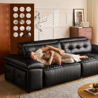 JASIWAY premium leather power reclining sleeper sofa featuring deep button-tufted backrests, adjustable panoramic headrests, and a unique open-concept recessed armrest with built-in storage, highlighting luxurious ergonomics, integrated technology, and space-saving functional furniture design for modern high-end homes.-Three quarter view with model lying down