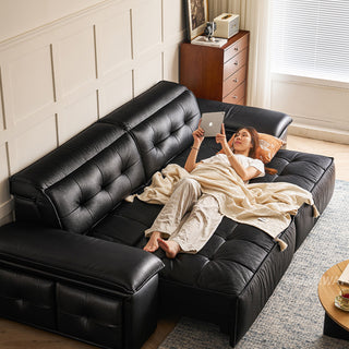 JASIWAY premium leather power reclining sleeper sofa featuring deep button-tufted backrests, adjustable panoramic headrests, and a unique open-concept recessed armrest with built-in storage, highlighting luxurious ergonomics, integrated technology, and space-saving functional furniture design for modern high-end homes.-High-angle view with model lying down
