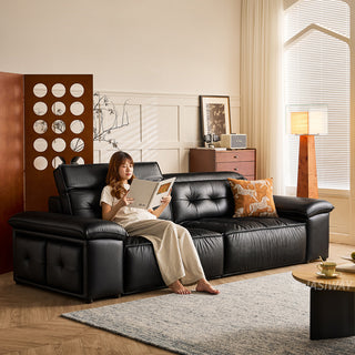 JASIWAY premium leather power reclining sleeper sofa featuring deep button-tufted backrests, adjustable panoramic headrests, and a unique open-concept recessed armrest with built-in storage, highlighting luxurious ergonomics, integrated technology, and space-saving functional furniture design for modern high-end homes.-Three quarter view with model sitting