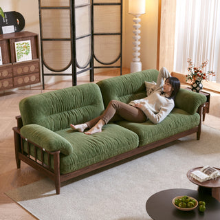 JASIWAY modern upholstered couch featuring a premium textured fabric over deeply tufted cushions, built on a sturdy mid-century walnut finish solid wood frame with exposed spindle arms, featuring a removable washable slipcover for an elegant yet functional living room seating solution.-High-angle view with model lying