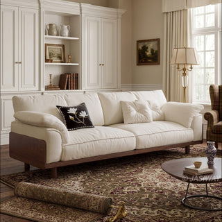 JASIWAY mid-century modern 3-seater sofa featuring premium top-grain leather upholstery with hand-stitched detailing, plush oversized armrests, and a sturdy solid wood exposed frame base in a walnut finish for a luxury living room aesthetic.-Three-quarter view