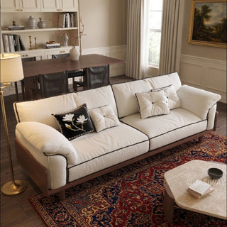 JASIWAY mid-century modern 3-seater sofa featuring premium top-grain leather upholstery with hand-stitched detailing, plush oversized armrests, and a sturdy solid wood exposed frame base in a walnut finish for a luxury living room aesthetic.-High-angle view