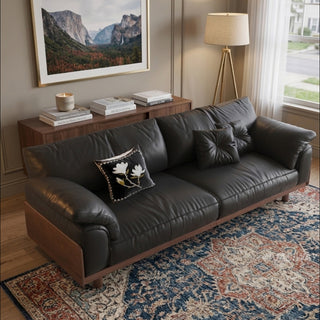 JASIWAY mid-century modern 3-seater sofa featuring premium top-grain leather upholstery with hand-stitched detailing, plush oversized armrests, and a sturdy solid wood exposed frame base in a walnut finish for a luxury living room aesthetic.-High-angle view