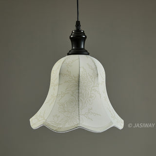 A vintage-style pendant lamp hangs illuminated against a solid, neutral grey background. The bell-shaped fabric shade features a delicate, light-colored floral and vine pattern with subtle scalloped edges. It is suspended by a dark, aged bronze-finish fixture and a black cord.