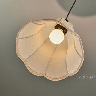 This upward-looking view captures the interior of a scalloped, bell-shaped pendant lamp, revealing its delicate, light-diffusing fabric and a warm, glowing light bulb. The structural ribs of the shade create a balanced, graceful form that emphasizes the artisan-quality craftsmanship of the piece. It serves as an elegant and functional accent, perfect for adding a touch of sophisticated charm to any curated living space.
