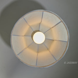 Looking down from above, this shot of the pendant light captures its internal structure. The round, glowing light bulb is centered within the shade, and the even radial spokes provide a balanced, geometric composition. The textured white fabric and neat edging emphasize the high quality and artisanal care in its construction.