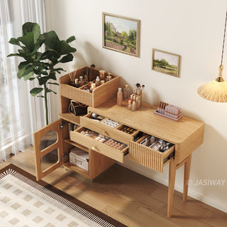High-angle lifestyle view of a modern wooden vanity desk with open drawers, fluted storage, and organized cosmetics in a warm bedroom setting.