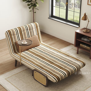 High-angle shot of a single convertible accent chair reclined into chaise lounge mode in striped fabric upholstery, featuring an attached side swiveling coffee tray and woven rattan panel detail, styled on a textured rug near a sunlit window.