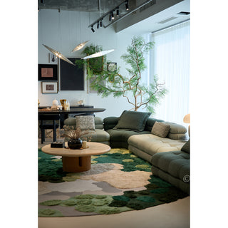 RINGCHEN hand-tufted round area rug with a 3D forest moss design, featuring sculptural high-low pile in shades of deep emerald, sage green, and earthy grey to mimic a natural forest floor.-Three-quarter high angle