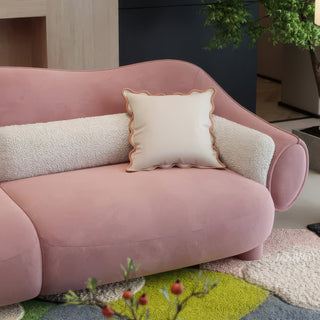 RINGCHEN modern luxury blush pink curved cloud sofa featuring a sculptural shell-inspired silhouette, premium deep-seat upholstered velvet fabric with decorative cream boucle lumbar pillows and ruffled accent cushions for a high-end designer living room aesthetic.-Medium shot