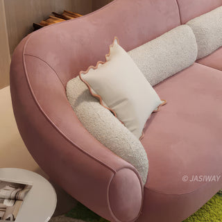 RINGCHEN modern luxury blush pink curved cloud sofa featuring a sculptural shell-inspired silhouette, premium deep-seat upholstered velvet fabric with decorative cream boucle lumbar pillows and ruffled accent cushions for a high-end designer living room aesthetic.-Close-up of armrest & texture