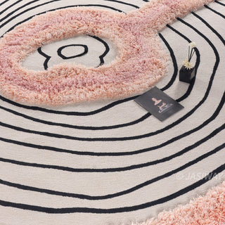 RINGCHEN petal pink and obsidian abstract round rug featuring a high-low tufted texture and organic circular ripples, showcases a hand-drawn tree ring motif with soft pink shaggy edges and crisp black line, blending modern minimalism with poetic visual storytelling.-Close-up