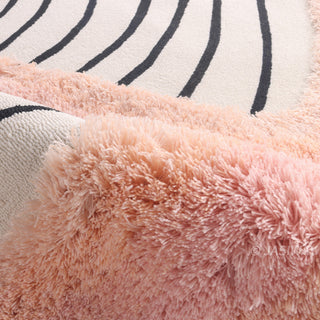 RINGCHEN petal pink and obsidian abstract round rug featuring a high-low tufted texture and organic circular ripples, showcases a hand-drawn tree ring motif with soft pink shaggy edges and crisp black line, blending modern minimalism with poetic visual storytelling.-Texture close-up