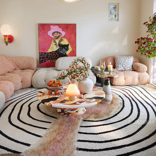 RINGCHEN petal pink and obsidian abstract round rug featuring a high-low tufted texture and organic circular ripples, showcases a hand-drawn tree ring motif with soft pink shaggy edges and crisp black line, blending modern minimalism with poetic visual storytelling.-Medium shot