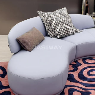 RINGCHEN luxury curved sectional sofa featuring a modular cloud couch silhouette with a mix of smooth premium leather and textured bouclé fabric. The sculptural design includes a distinctive rotating lounge seat, an integrated low-profile chaise, and a sweeping ergonomic backrest, showcasing a seamless blend of modern artistry and functional seating for high-end designer living rooms. -Medium shot