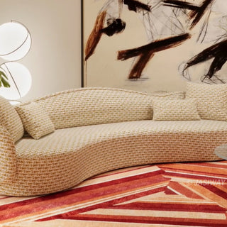 RINGCHEN luxury curved sofa featuring a sculptural serpentine silhouette and cloud-like contoured backrest, upholstered in a premium textured woven fabric with a detailed oatmeal and golden-hued interlaced pattern, designed for high-end organic modern living rooms and designer-led residential interiors.-Medium shot
