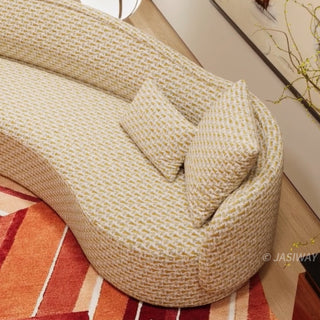 RINGCHEN luxury curved sofa featuring a sculptural serpentine silhouette and cloud-like contoured backrest, upholstered in a premium textured woven fabric with a detailed oatmeal and golden-hued interlaced pattern, designed for high-end organic modern living rooms and designer-led residential interiors.-High-angle medium shot