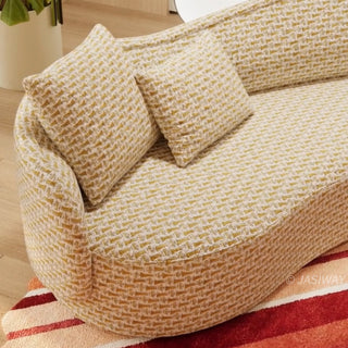 RINGCHEN luxury curved sofa featuring a sculptural serpentine silhouette and cloud-like contoured backrest, upholstered in a premium textured woven fabric with a detailed oatmeal and golden-hued interlaced pattern, designed for high-end organic modern living rooms and designer-led residential interiors.-Close-up of armrest