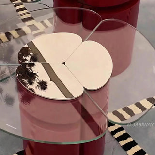 RINGCHEN modern cluster coffee table set featuring three modular nesting tables with premium tempered glass tops and sculptural petal-shaped metal bases in a bold red finish with gold accents. This luxury living room furniture set showcases a sophisticated clover-like silhouette and a sleek, high-gloss industrial design ideal for upscale interior decor.-Close-up of tabletop
